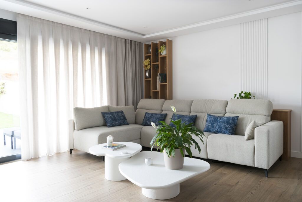 Cómo distribuir un salón-. Sofá con estantería que organiza el espacio de salón. Icónica Interiors